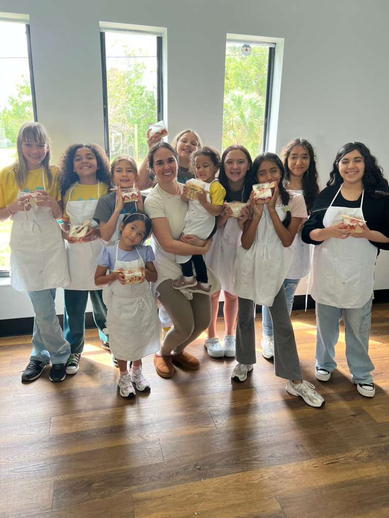 Connect students and an instructor smiling together after a hands-on cooking activity